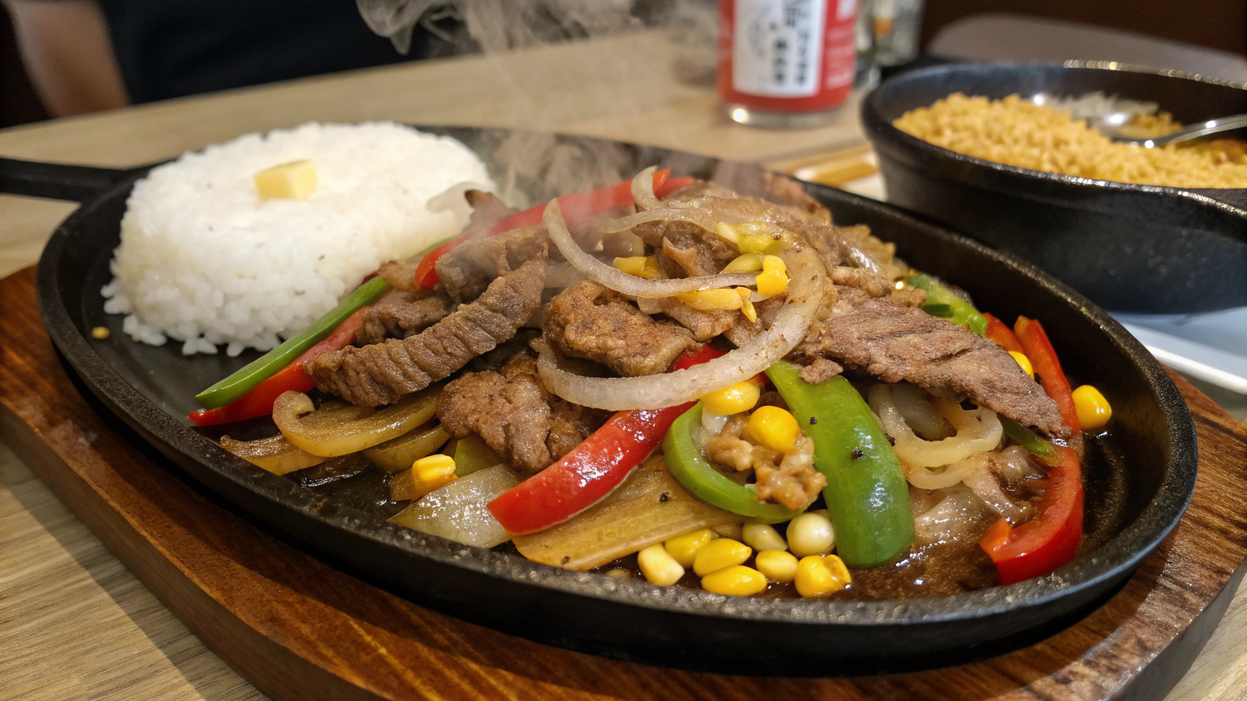 "Pepper Lunch sizzling hot plate with beef, bell peppers, onions, and corn in a delicious arrangement."